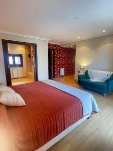 1 dormitorio con 1 cama grande y 1 sofá azul en Precioso Chalet Vista Mar en Mar del Plata