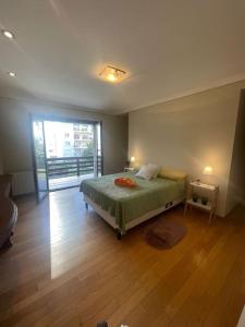 a bedroom with a bed and a large window at Precioso Chalet Vista Mar in Mar del Plata