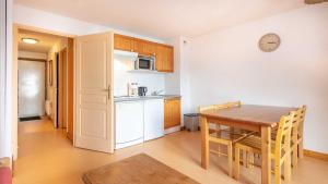 a kitchen and dining room with a wooden table at Les Grizzlis - 27 - Appart vue montagne - 6 pers in Saint-Sorlin-dʼArves