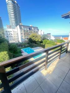 a balcony with a wooden fence and a swimming pool at Precioso Chalet Vista Mar in Mar del Plata