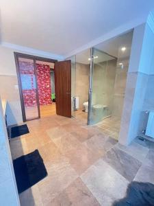 a large bathroom with a toilet and a glass door at Precioso Chalet Vista Mar in Mar del Plata