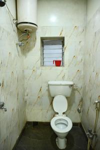 łazienka z białą toaletą i oknem w obiekcie Hotel Komala Vilas w mieście Kolkata