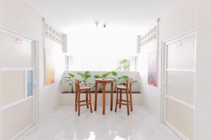 une salle à manger avec des murs blancs, une table et des chaises dans l'établissement RedDoorz Syariah near GOR Bung Karno Nganjuk, à Nganjuk