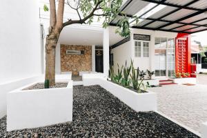 une maison avec un arbre dans la cour avant dans l'établissement RedDoorz Syariah near GOR Bung Karno Nganjuk, à Nganjuk
