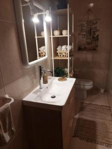 a bathroom with a sink and a toilet and a mirror at Ferienhaus Casa do mar mit seitlichem Meerblick in Vila Chã