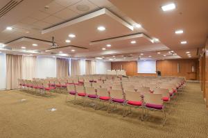 une salle de conférence vide avec des chaises et un podium dans l'établissement Novotel Tunis, à Tunis