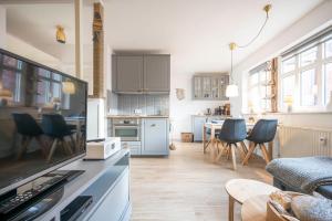 a kitchen and living room with a table and chairs at Deine Juist Ferienwohnung Strandburg Juist in Juist