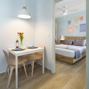 a bedroom with a bed and a white table and chairs at THYME Brand New 1BD apart in the heart of Rethymno in Rethymno