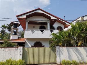a house with a fence in front of it at Sun and Sand Apartment in Ahangama