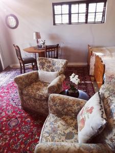 ein Wohnzimmer mit Couch und Tisch in der Unterkunft Pepper Tree Guesthouse in Bloemfontein