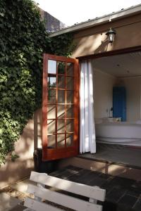 ein Badezimmer mit einer Glastür und einer Badewanne in der Unterkunft Pepper Tree Guesthouse in Bloemfontein