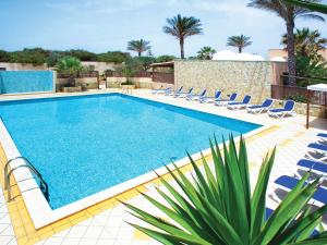 ein Pool mit Stühlen und ein Resort in der Unterkunft Oasis Hotel Residence Resort in Lampedusa