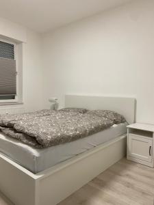 a white bedroom with a bed and a window at Ferienwohnung Edi in Mülheim an der Ruhr