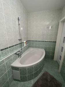 un bagno con una grande vasca in una camera piastrellata di Apartmán u Lukáša a Žilina