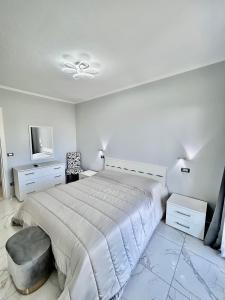 a white bedroom with a bed and a tv at Agriturismo Azzurra Biricchina - Suites in Riva Ligure