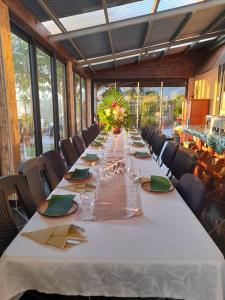 a long long table in a room with chairs at Ferme Lebon Papillon LA ROULOTTE in Le Tampon