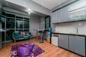 ein Wohnzimmer mit einem Sofa und einer Küche in der Unterkunft RedLiving Apartemen Easton Park Jatinangor - Azhimah Rooms in Sumedang