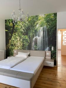 1 dormitorio con un mural de cascada en la pared en Hotel St. Hubertus, en Wallmerod