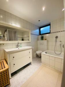 ein Badezimmer mit einer Badewanne, einem Waschbecken und einem WC in der Unterkunft Ferienwohnung Elisa in Tiefenbach