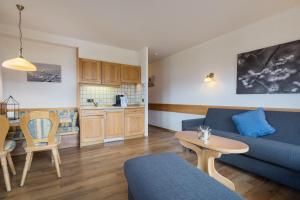 ein Wohnzimmer mit einem blauen Sofa und einem Tisch in der Unterkunft Landhaus Kopp in Oberstdorf