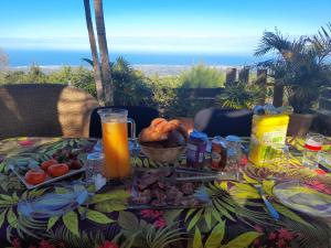 una mesa con comida y zumo de naranja. en Ferme Lebon Papillon LA ROULOTTE, en Le Tampon