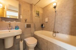 a bathroom with a toilet and a sink and a tub at Skyline Retreat with Unmatched Panaromic Views and Secure Parking in Liverpool