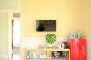 a kitchen with a red refrigerator and a tv on the wall at Villa Várzea - Garden Suite in Várzea