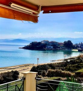 a view of the ocean from a balcony of a house at Golden Coast Panagias Apartment in Volos