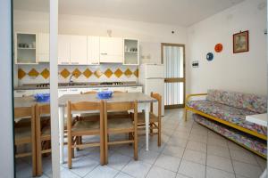 cocina y sala de estar con mesa y sofá en Villa Roswal, en Rosolina Mare