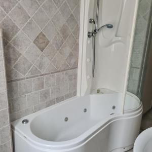 a white bath tub in a bathroom with a shower at via Matteotti 102 in Bazzano