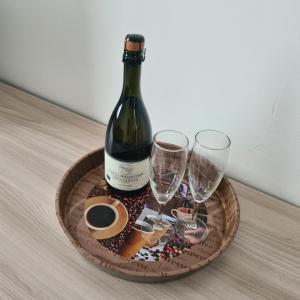 a bottle of wine and two glasses on a tray at via Matteotti 102 in Bazzano