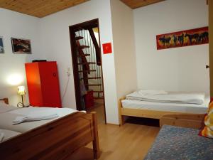 um quarto com duas camas e uma porta com uma escada em ciao-aschau Sachrang Haus Spitzstein FeWo Angelika em Aschau