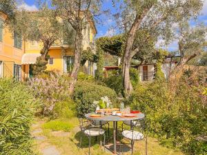 einen Tisch und Stühle in einem Garten mit Bäumen in der Unterkunft L'uliveto di Santa con piscina in Santa Margherita Ligure
