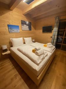 1 dormitorio con 1 cama grande con sábanas blancas en Almhütte en Lachtal