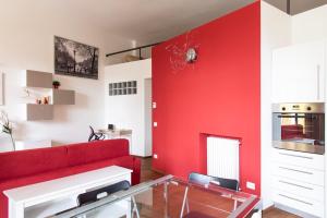 salon z czerwoną kanapą i czerwoną ścianą w obiekcie Youhosty - Caviglia 5 w Mediolanie