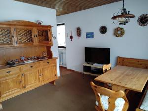 a kitchen with a wooden table and a television at ciao-aschau Sachrang Haus Spitzstein FeWo Klos in Aschau