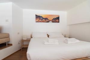 sypialnia z białym łóżkiem i 2 ręcznikami w obiekcie Youhosty - Caviglia 5 w Mediolanie