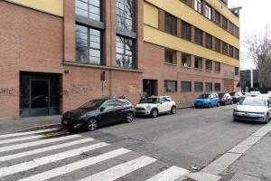 un groupe de voitures garées devant un bâtiment dans l'établissement Youhosty - Caviglia 5, à Milan
