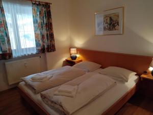 a large bed in a bedroom with a window at ciao-aschau Grenzhub FeWo 312 Göke in Aschau