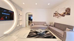 a living room with a couch and a tv at Appartamento Arlena by Salento Affitti in Alliste