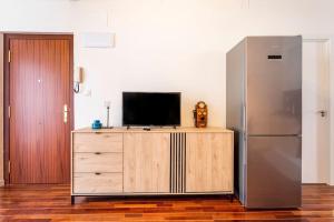uma televisão em cima de uma cómoda de madeira com um frigorífico em 7P céntrico piso con encanto em Valência