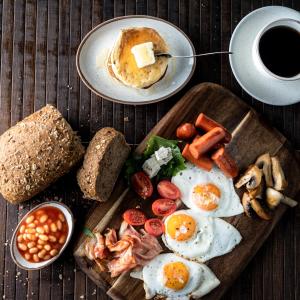 a plate of breakfast food with eggs and bread and a cup of coffee at Takis Family Corfu in Kontokali