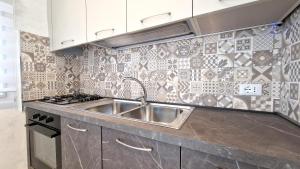 a kitchen with a sink and a stove at Appartamento Arlena by Salento Affitti in Alliste