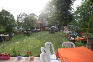 un patio al aire libre con mesas y sillas y un jardín en mehmet efendi en Safranbolu