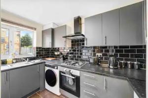 a large kitchen with a washer and dryer in it at 4 bed Townhouse- Free parking in London