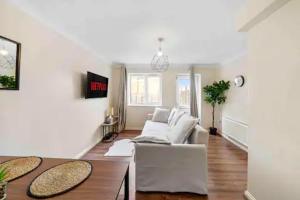 - un salon avec un canapé blanc et une table dans l'établissement 4 bed Townhouse- Free parking, à Londres