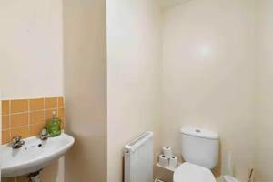 ein Badezimmer mit einem weißen WC und einem Waschbecken in der Unterkunft 4 bed Townhouse- Free parking in London