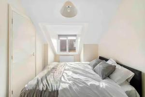 a bedroom with a white bed with pillows at 4 bed Townhouse- Free parking in London