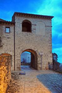 un gran edificio de ladrillo con un arco en La casa di Carlotta, en Cerreto di Spoleto
