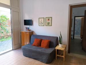 アヴォラにあるCasa La Loggia e il Mare a 50mtのリビングルーム(青いソファ、オレンジ枕2つ付)